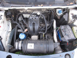 Engine. Not my picture, but my car none the less. Note the rocker cover (72 degrees! ha!) and the 1.1 on the air filter housing changed to 1.4 with pen.